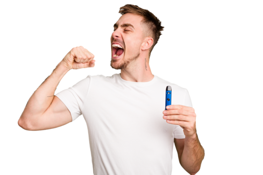 Young caucasian man holding a vaporizer cut out isolated raising fist after a victory, winner concept.