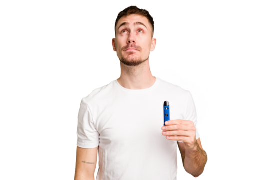 Young caucasian man holding a vaporizer cut out isolated dreaming of achieving goals and purposes