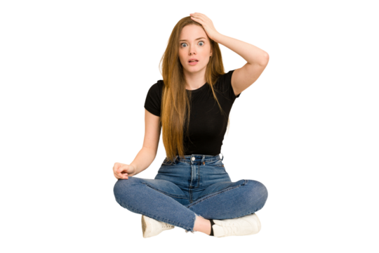 Young redhead woman sitting on the floor cut out isolated being shocked, she has remembered important meeting.