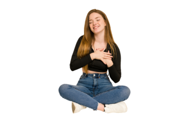 Young redhead woman sitting on the floor cut out isolated with fingers on lips keeping a secret.