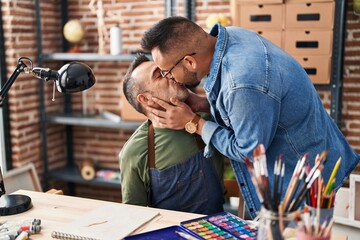 Two men artists drawing on notebook kissing at art studio