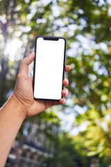 Man holding smartphone showing white blank screen at park