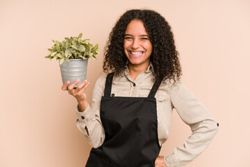 Young african american gardener woman holding a plant isolated
