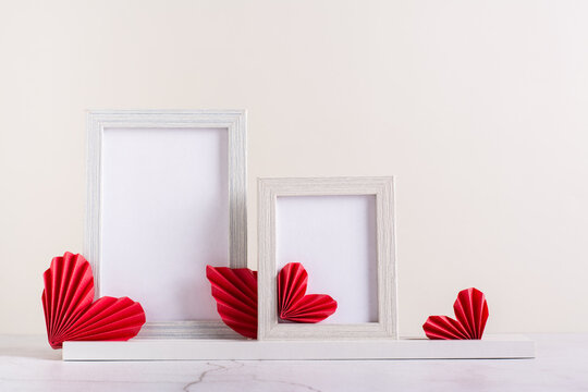Two blank photo frames decorated with DIY paper hearts. Home decor.