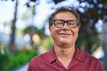 Middle age man smiling confident standing at park