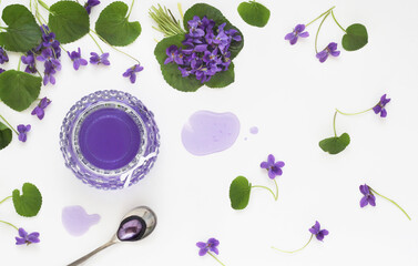 Syrup and jelly from viola odorata flowers in glass, spoon and violet fresh flower with leaves...