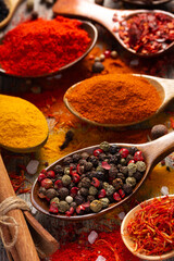 Pepper spice mix in spoon and variety spices at table background. Dried spice and seeds