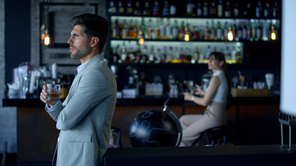 Businessman holding whiskey glass at cafe. Elegant people resting concept