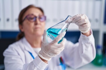 Senior woman scientist measuring liquid at laboratory