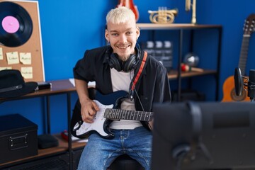 Young caucasian man musician playing electrical guitar at music studio