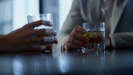 Partners hands drinking whiskey in restaurant closeup. Colleagues with bourbon