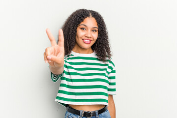 Obraz premium Young african american woman isolated on white background joyful and carefree showing a peace symbol with fingers.