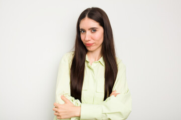 Young caucasian woman isolated on white background suspicious, uncertain, examining you.