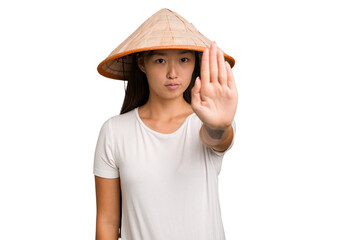Obraz na płótnie Canvas Young asian woman wearing a Vietnamese hat isolated standing with outstretched hand showing stop sign, preventing you.
