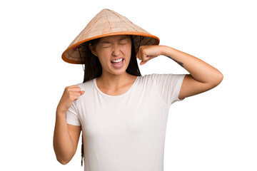 Young asian woman wearing a Vietnamese hat isolated raising fist after a victory, winner concept.