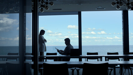 Fototapeta premium Secretary silhouette giving report papers to manager. Corporate lifestyle