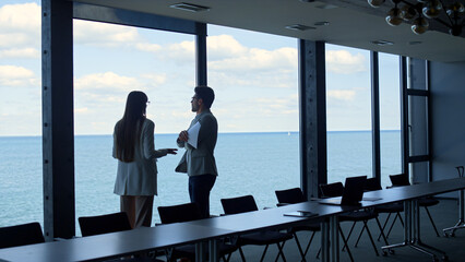 Fototapeta na wymiar Financial managers discussing contract at panorama window. Business team argue