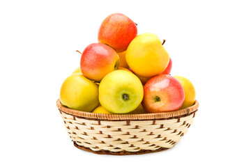 Ripe apples in a wicker basket isolated on white.