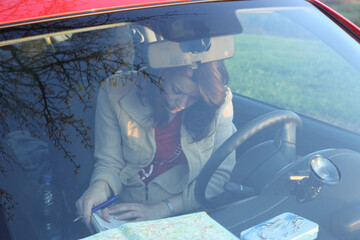 woman looking away on maps sitting in car