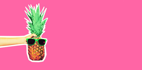 Hand showing stylish pineapple with sunglasses isolated on pink background, magazine style, blank copy space for advertising text