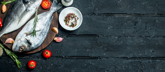 Raw sea fish dorado with spices and vegetables.