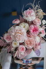 Beautiful flowers. Beautiful flower arrangement in a box on dark blue background on coffee table. Bouquet of tenders peonies a girl for mother's day, valentine's day, Woman's day 8 march.