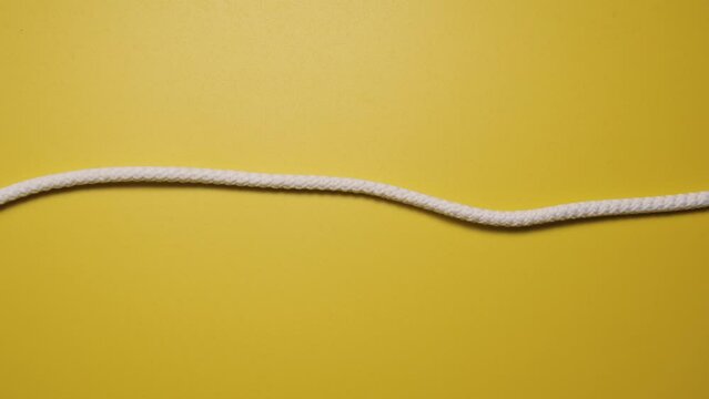 Pulse and vibration. Stop motion animation made of white lace on a yellow background. Sine wave and oscilloscope concept