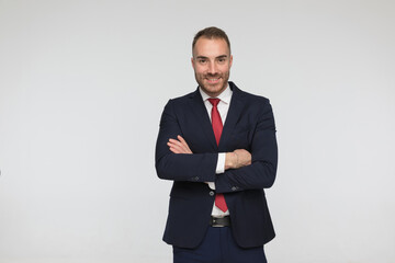 attractive young man in elegant suit crossing arms and smiling