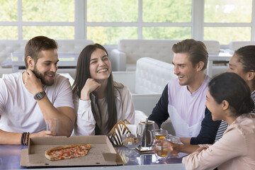 Happy joyful young friends having fun in pizzeria, meeting and talking in cafe, sitting at table with pizza in box, transparent dish, hot tea, speaking, laughing, enjoying friendship, celebrating