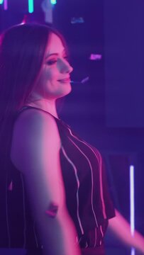 Happy women. Dancing friends. Night party. Cheerful ladies enjoying dance in confetti rain in neon light purple illumination. Vertical video.
