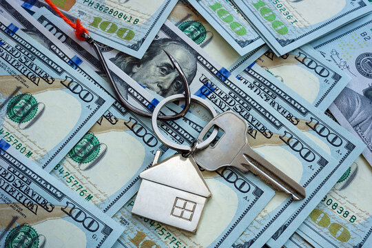 Real estate fraud concept. The hook and the key to the house lie on the money.