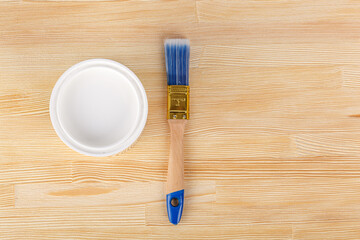 white paint with a brush on a wooden background with texture