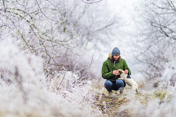 beautiful  winter  landscape with man playing dog background with snow covered trees Сhristmas hoarfrost Snow  path dry grass White Alley background Moldova.