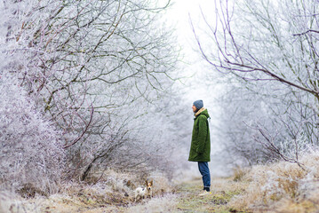 beautiful  winter  landscape with man playing dog background with snow covered trees Сhristmas hoarfrost Snow  path dry grass White Alley background Moldova.