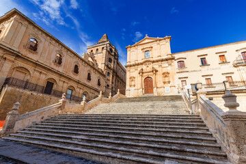 Fototapeta na wymiar Church of Saint Francis of Assisi, an iconic building in the historical center of Noto, a picturesque town in Sicily, Italy. To the left, is the building of Seminario Vescovile.