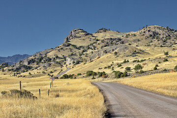 Country road curves gently uphill in Montana in symbol rambling travel