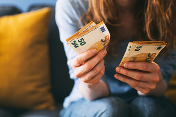 Woman counting Euro cash at home - obrazy, fototapety, plakaty