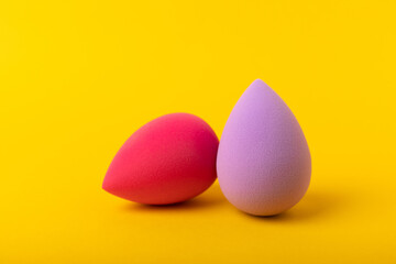 Beauty blender on yellow background.Bright sponges for make-up cosmetics. Makeup products. Beauty concept. Place for text. Space for copy. Flat lay