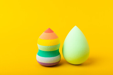 Beauty blender on yellow background.Bright sponges for make-up cosmetics. Makeup products. Beauty concept. Place for text. Space for copy. Flat lay