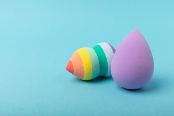 Beauty blender on blue background.Bright sponges for make-up cosmetics. Makeup products. Beauty concept. Place for text. Space for copy. Flat lay