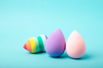 Beauty blender on blue background.Bright sponges for make-up cosmetics. Makeup products. Beauty concept. Place for text. Space for copy. Flat lay
