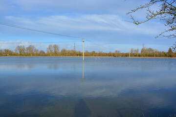 A utility pole is under water on a flooded field after heavy rainfall . Rural Oxfordshire in...