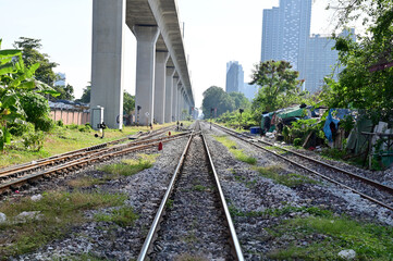 BANGKOK, THAILAND - January 15, 2023 : Railroad tracks let the train run through with nature background, Selective focus with shallow depth of field.