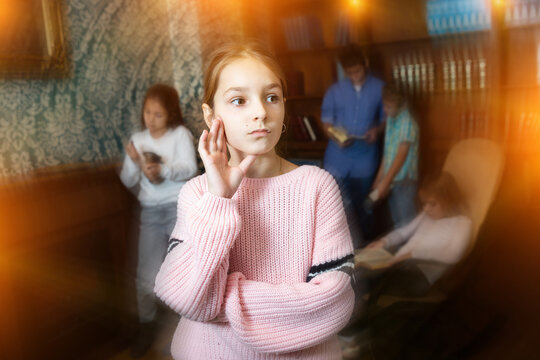 Pensive tween girl trying to solve riddles in quest room. Toned image with visual effect