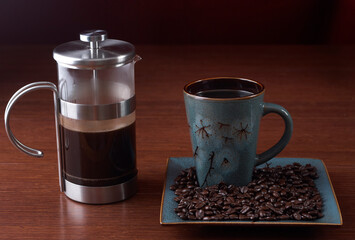  French press and a coffee cup on a wood background