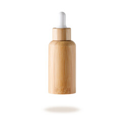 Glass dropper bottle with covering of bamboo wood for face serum or essential oil or pharmaceutical tincture. Bamboo wooden bottle flying isolated on white background.