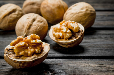 Peeled walnut on wooden background.