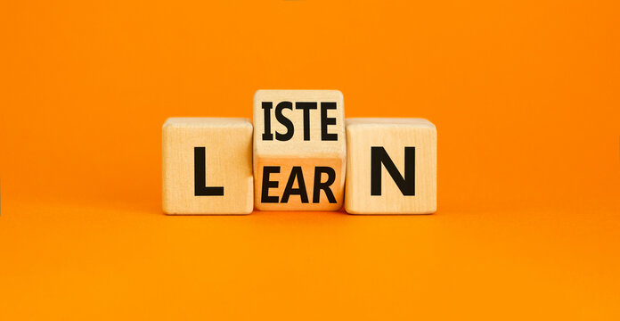 Listen and learn symbol. Concept word Listen Learn on wooden cubes. Beautiful orange table orange background. Business, education and listen and learn concept. Copy space.