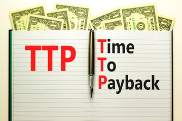 TTP time to payback symbol. Concept words TTP time to payback on white note on a beautiful background from dollar bills. Business TTP time to payback concept. Copy space.