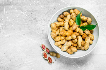 Peanuts with green leaves in the bowl .